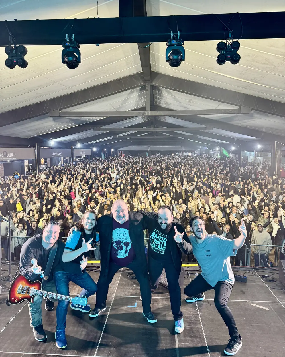 Amigos do Rock no palco da Expoqueijo, em Araxá, com o público lotando a tenda