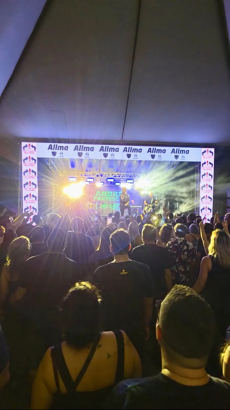 Público lotando a frente do palco iluminado