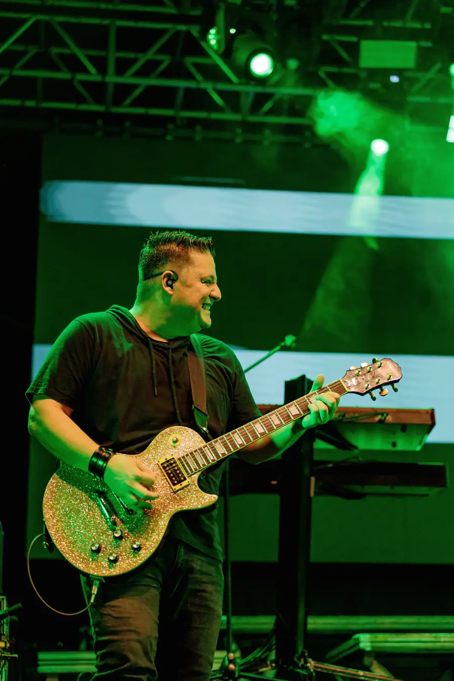 Guitarrista tocando no palco com luzes verdes